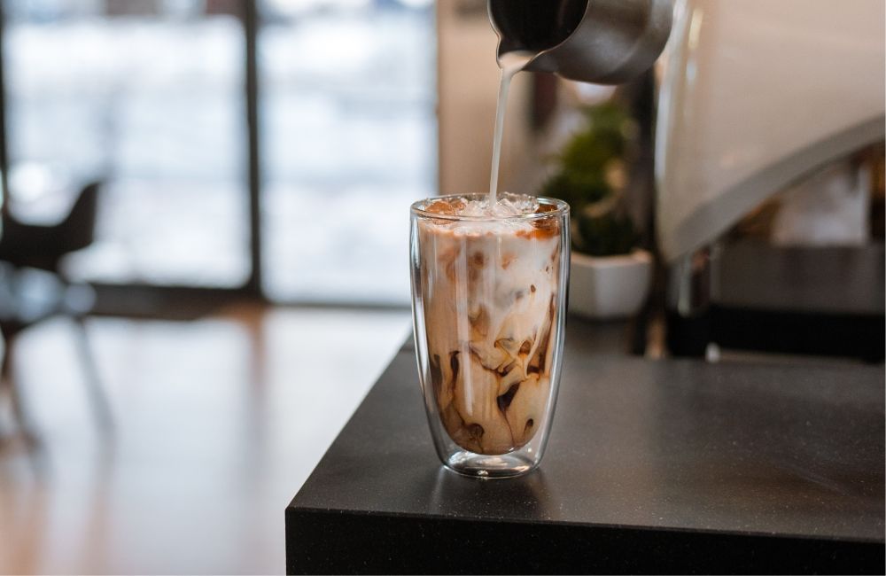 blog-ineffablecoffee-roaster-coffee-in-summer-3 Un iced latte al que se le está echando leche, un cremoso bebida de café en verano