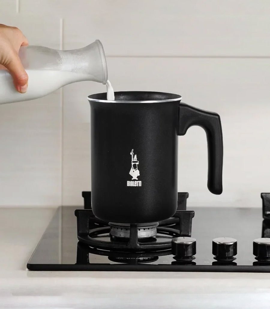 Calentando leche en la hornilla con espumador de leche manual Bialetti